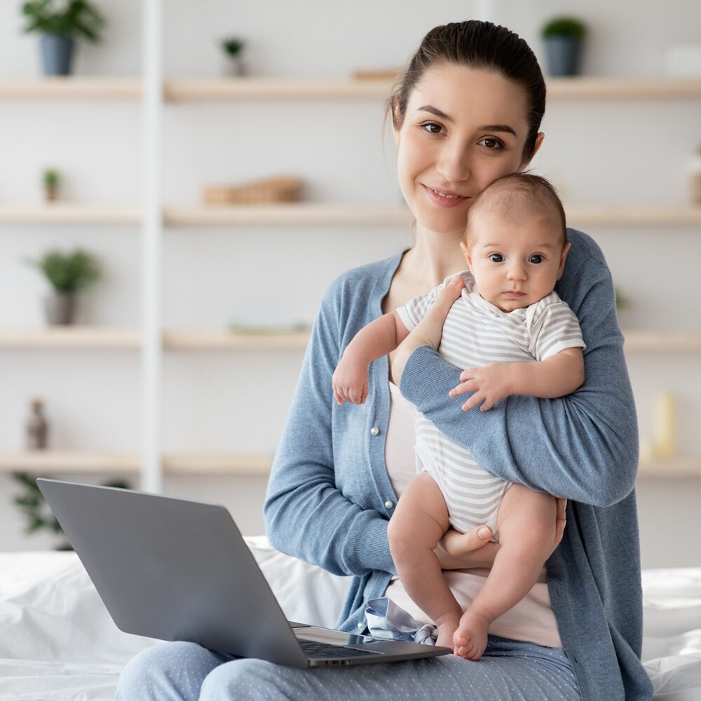 sleep consultant holding baby in front of laptop