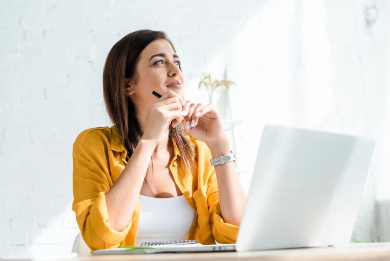 woman in front of laptop thinking of business names